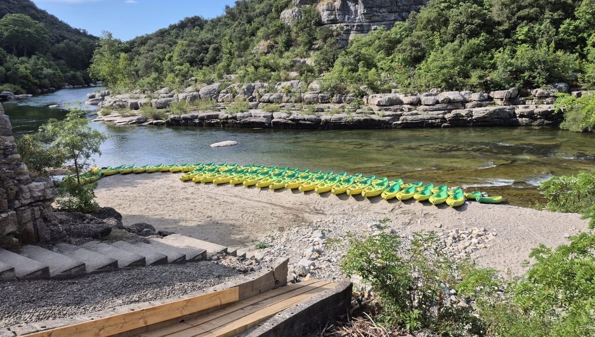 Canoës alignés sur la plage de galets au bord de l'Hérault